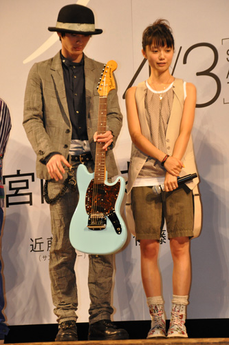 卒業生にプレゼントされたギターを持つ高良健吾（左）と宮崎あおい（右）