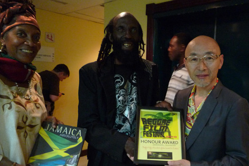 ジャマイカで受賞時の石井志津男監督（右）と、 Barbara Blake Hannah（映画祭を主催するジャマイカ・フィルム・アカデミーのエグゼクティブ・ディレクター／左） 、 Carl Bradshaw（映画『Harder They Come』にも出演している有名俳優／右）