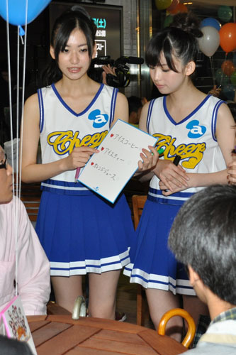 カフェでメニュー片手に注文を取るアイドル。西田有沙（左）と斉藤リナ（右）