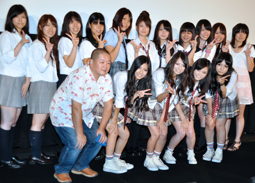 前列左から藤咲淳一監督、TOMOMI、HARUNA、RINA、MAMI。後列は女子コーラス隊