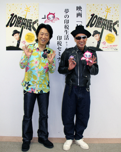 高橋ジョージ（左）とテリー伊藤（右）。テリーが手に持っているのは、この映画のために開発されたキャラクター「ナニティー」