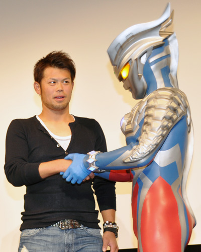 ウルトラマンゼロと握手する千葉ロッテマリーンズの今江敏晃選手