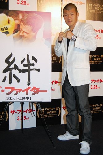 自ら「絆」と書き込んだポスターの前でファイティングポーズを決める亀田興毅