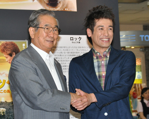 石原慎太郎東京都知事（左）と固い握手を交わす佐藤隆太（右）