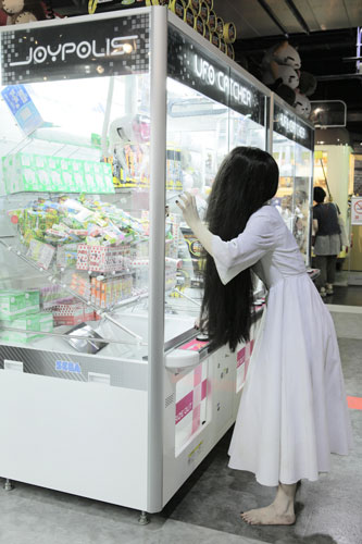 ゲームセンターでクレーンゲームに挑戦する貞子
(C) 2012「貞子3D」製作委員会