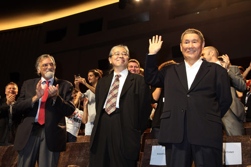 上映後のスタンディングオベーションに笑顔で手を振る北野武監督（右）。隣は映画プロデューサーで所属事務所・オフィス北野の代表でもある森昌行
(C) KAZUKO WAKAYAMA