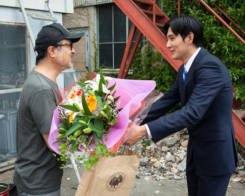 松田龍平（右）に花束を贈呈する松尾スズキ監督（左）