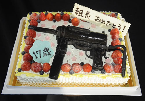 機関銃の飾りがついたバースデーケーキ