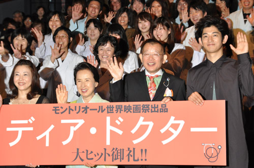 白衣を着たディア・ドクターたちに囲まれた登壇者たち。左から西川美和監督、八千草薫、笑福亭鶴瓶、瑛太