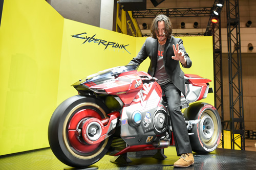 キアヌ・リーヴスが東京ゲームショウ訪問！ゲームに登場する実物大バイクと記念撮影