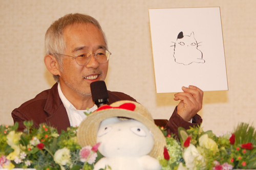 コニャラと名前を書く前の色紙を手にする鈴木敏夫