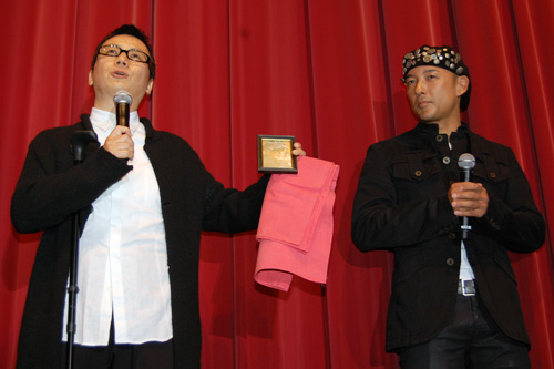 深作欣二監督の写真を取り出す片岡公生プロデューサー（左）と山本太郎（右）
