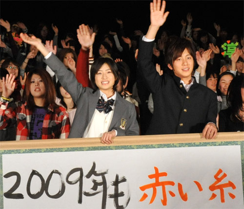 舞台挨拶後、書き初めを前に手を振る南沢奈央と溝端淳平。