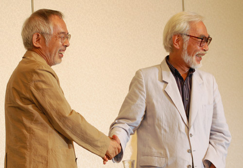 握手を交わす鈴木敏夫プロデューサー（左）と宮崎駿監督（右）