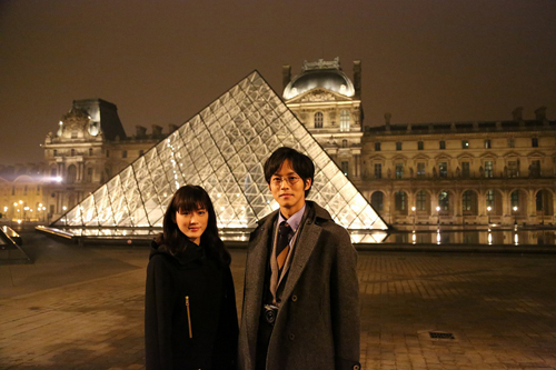 ルーヴル美術館前のピラミッドの前に立つ綾瀬はるか（左）と松坂桃李（右）
(C) 2014映画「万能鑑定士Q」製作委員会