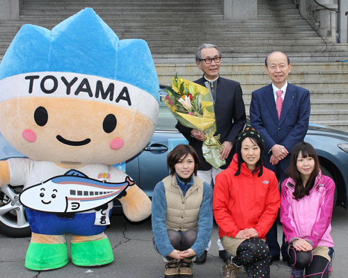 後列左から木村大作監督、石井隆一富山県知事。前列は県庁観光課の女性3人。左は富山県のゆるキャラ「きときと君」