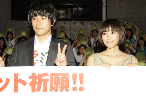 観客たちが掲げたキャベツを背にカメラに収まった松山ケンイチ（左）と麻生久美子（右）