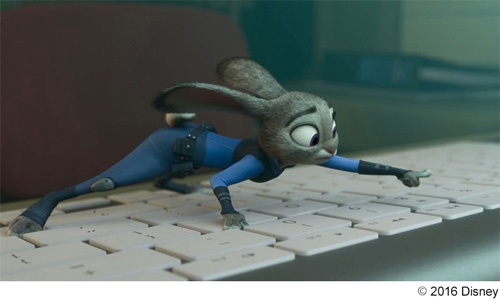 小さな体を精一杯伸ばして、ゾウのPCのキーボードを叩こうとするウサギのジュディ
(C) 2016 Disney