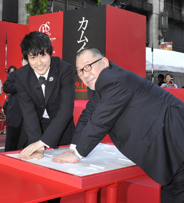 シネ・フェスタ新宿の記念の手形をとる松山ケンイチ（左）と崔洋一監督（右）。キャスト・監督の手形をかたどったこのモニュメントは、新宿区役所に飾られるという。