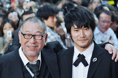  9月13日に新宿で行われた『カムイ外伝』のレッドカーペット・セレモニーにて。カムイ役の松山ケンイチと肩を組む崔監督。